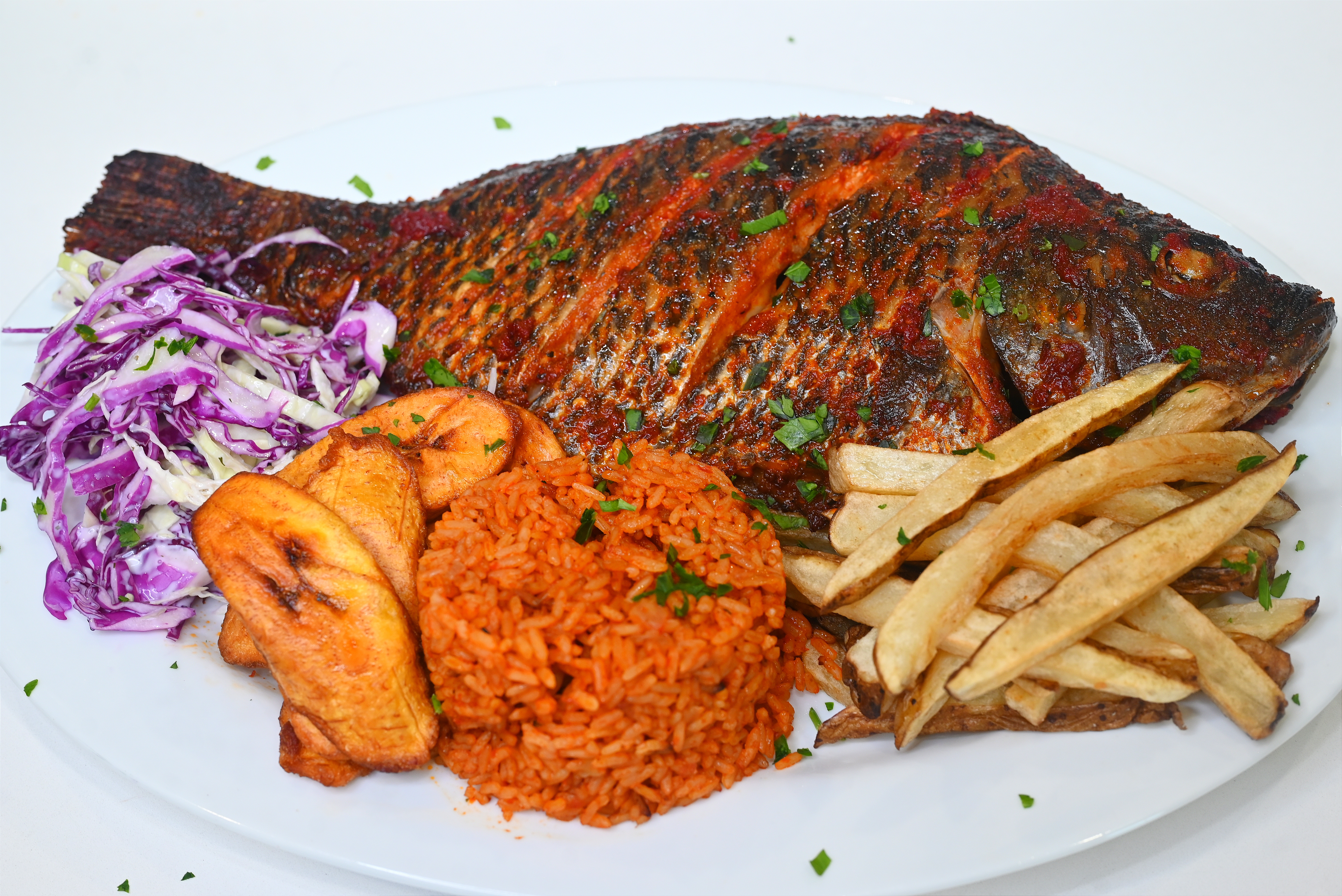Grilled Tilapia Fish: with side of jollof rice or fried rice, coleslaw and plantain
